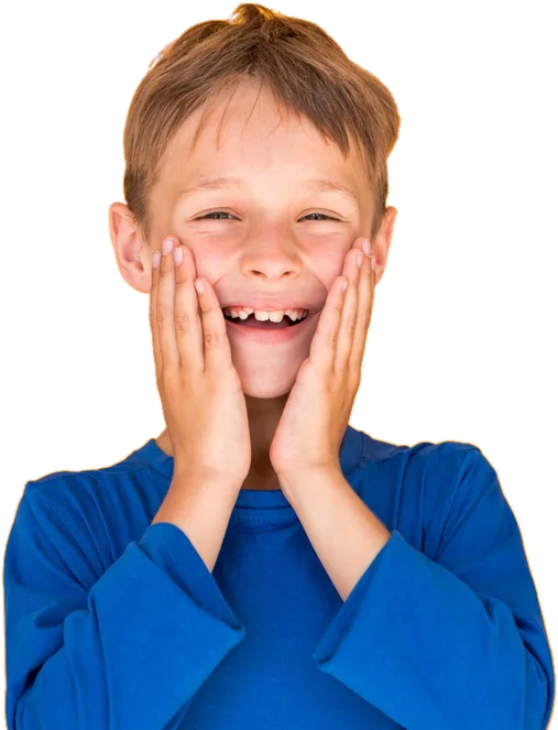 A smiling boy in a blue top with his hands on his cheeks