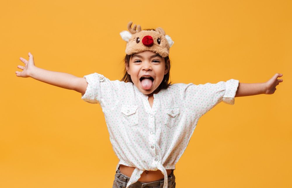 A girl with her arms flung wide, laughing